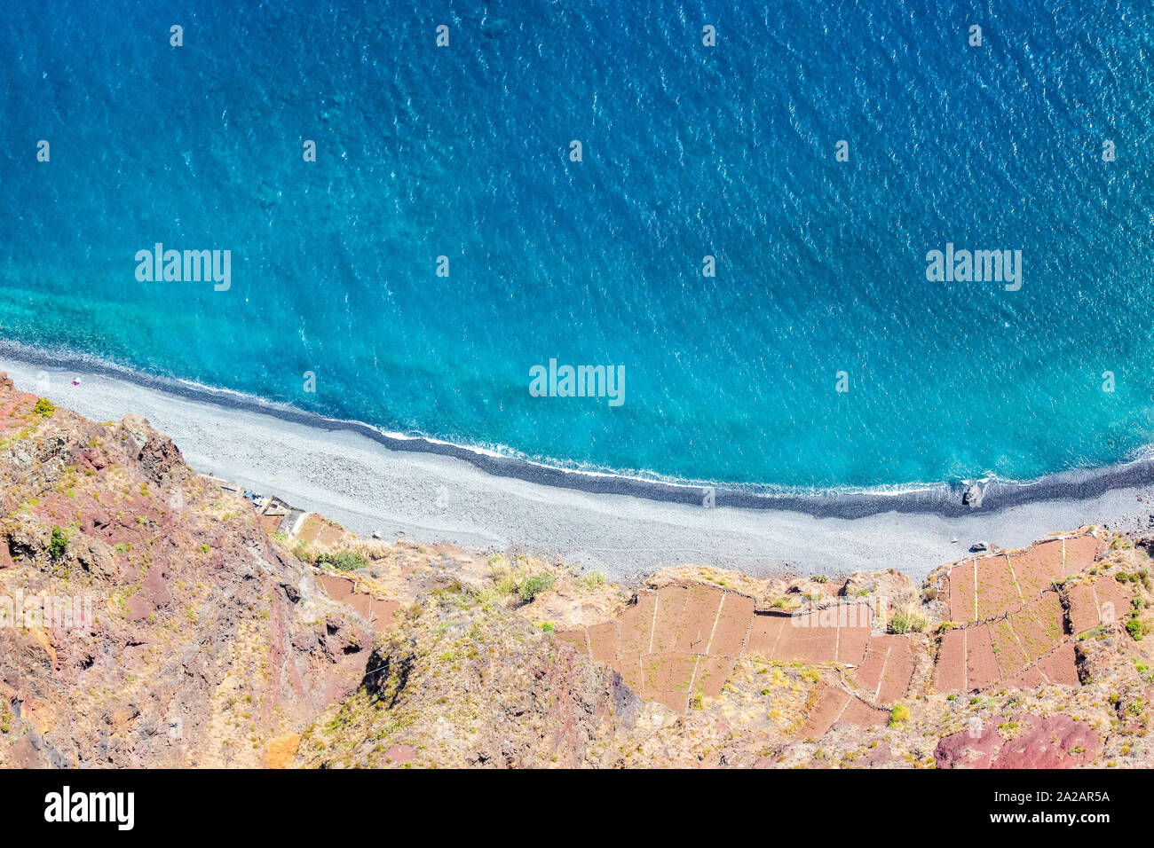 Vista aerea del blu oceano Atlantico, spiaggia e campi adiacenti sulla costa meridionale dell'isola di Madeira, Portogallo. Paesaggio di antenna, natura straordinaria. Estate vibes. Foto Stock