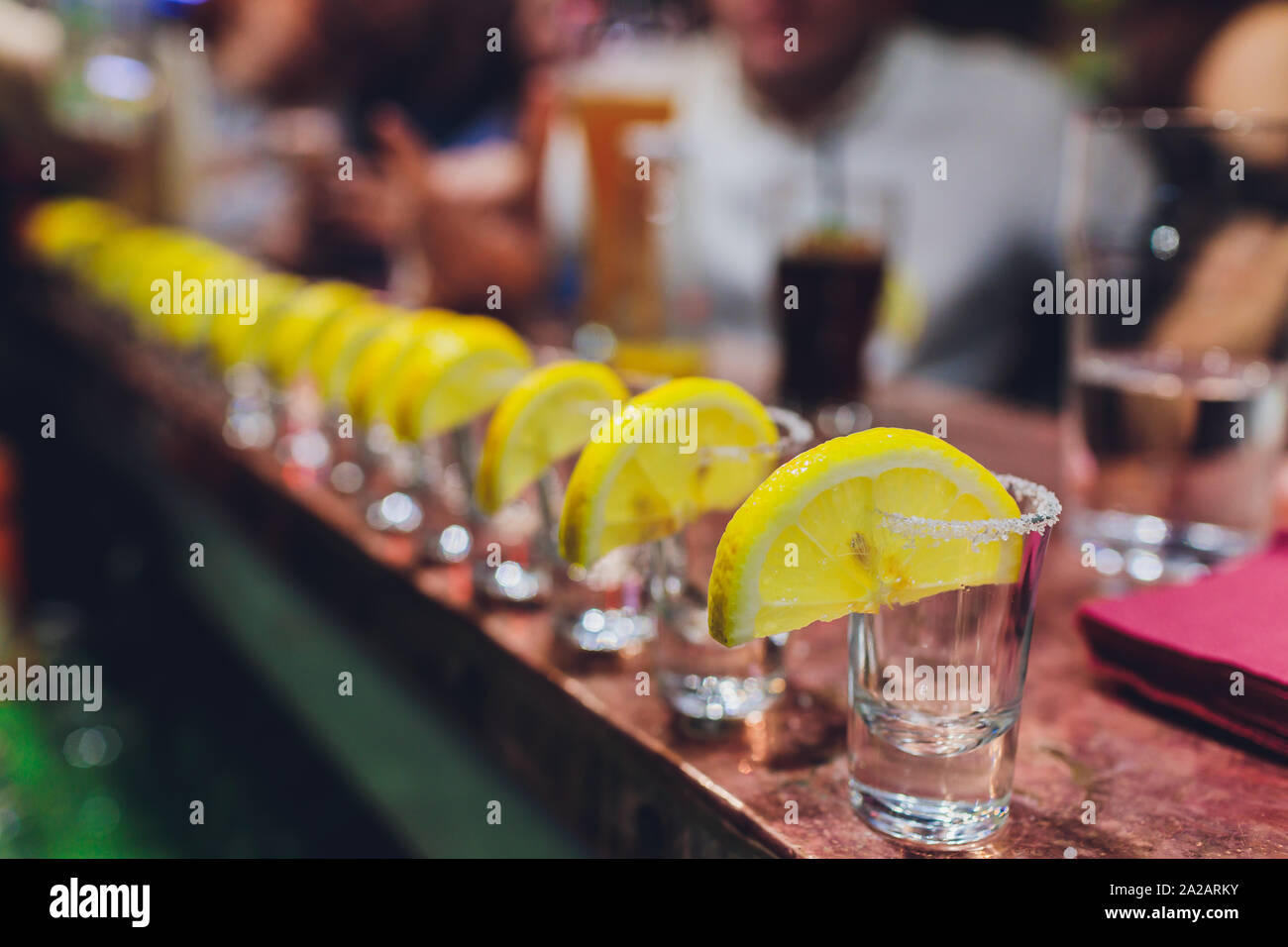 Barista versando forte bevanda alcolica in piccoli bicchieri sul bar, scatti. Foto Stock