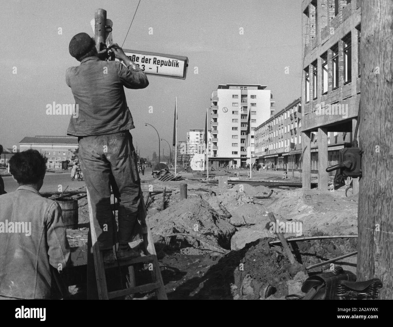 Lavoratori Appendere un cartello stradale con la scritta "traccia der Republik' per una nuova zona residenziale attualmente in costruzione in Stalinstadt (ora Eisenhuettenstadt). Foto Stock