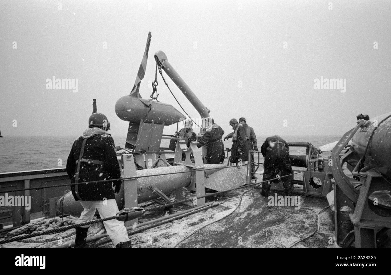 La Lindau classe minehunter costiere durante un esercizio del 6. Minensuchgeschwader (sesta miniera squadrone di spazzamento) nel Mare del Nord. I soldati al lavoro sul minesweeping ingranaggio del prato fiorito. Foto Stock