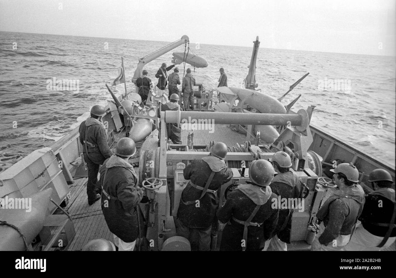 La Lindau classe minehunter costiere durante un esercizio del 6° Squadrone minesweeping nel Mare del Nord. I soldati al lavoro sul minesweeping ingranaggio del prato fiorito. Qui, tenendo fuori un corpo galleggiante della minesweeping gear. In primo piano il verricello per i cavi di acciaio del minesweeping gear. Foto Stock