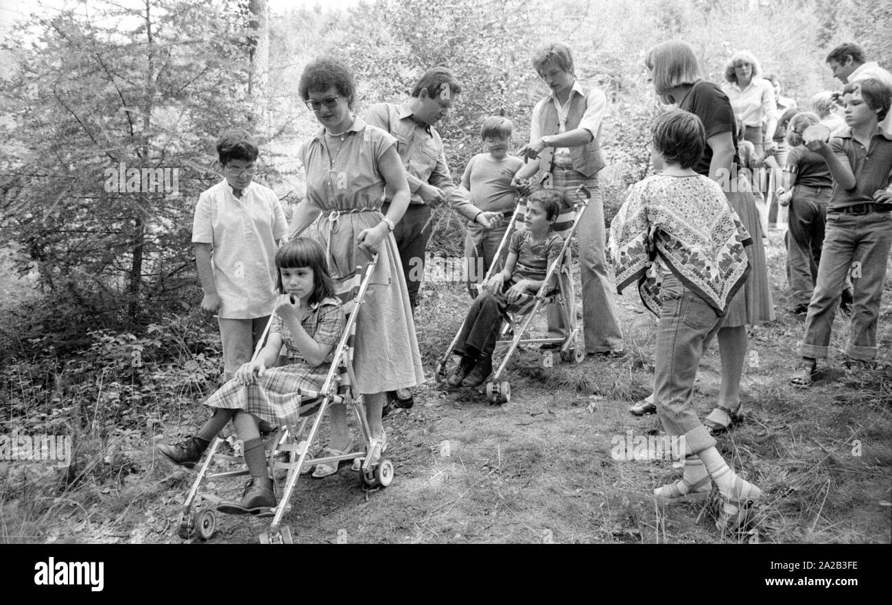 Una giornata del bosco è stato organizzato per i bambini disabili con una escursione nella foresta bavarese in prossimità di Kelheim. La foto mostra il gruppo con i loro accompagnatori sulla strada attraverso la foresta, alcuni bambini sono spinti nella baby carrelli. Foto Stock Una giornata del bosco è stato organizzato per i bambini disabili con una escursione nella foresta bavarese in prossimità di Kelheim. La foto mostra il gruppo con i loro accompagnatori sulla strada attraverso la foresta, alcuni bambini sono spinti nella baby carrelli. Foto Stock
