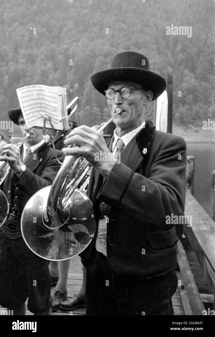 Un gruppo di musica Riproduzione di brani sulla penisola Hirschau in Schoenau am Koenigssee. Sulla penisola è meta di pellegrinaggio di San Bartolomeo la Chiesa. Foto Stock