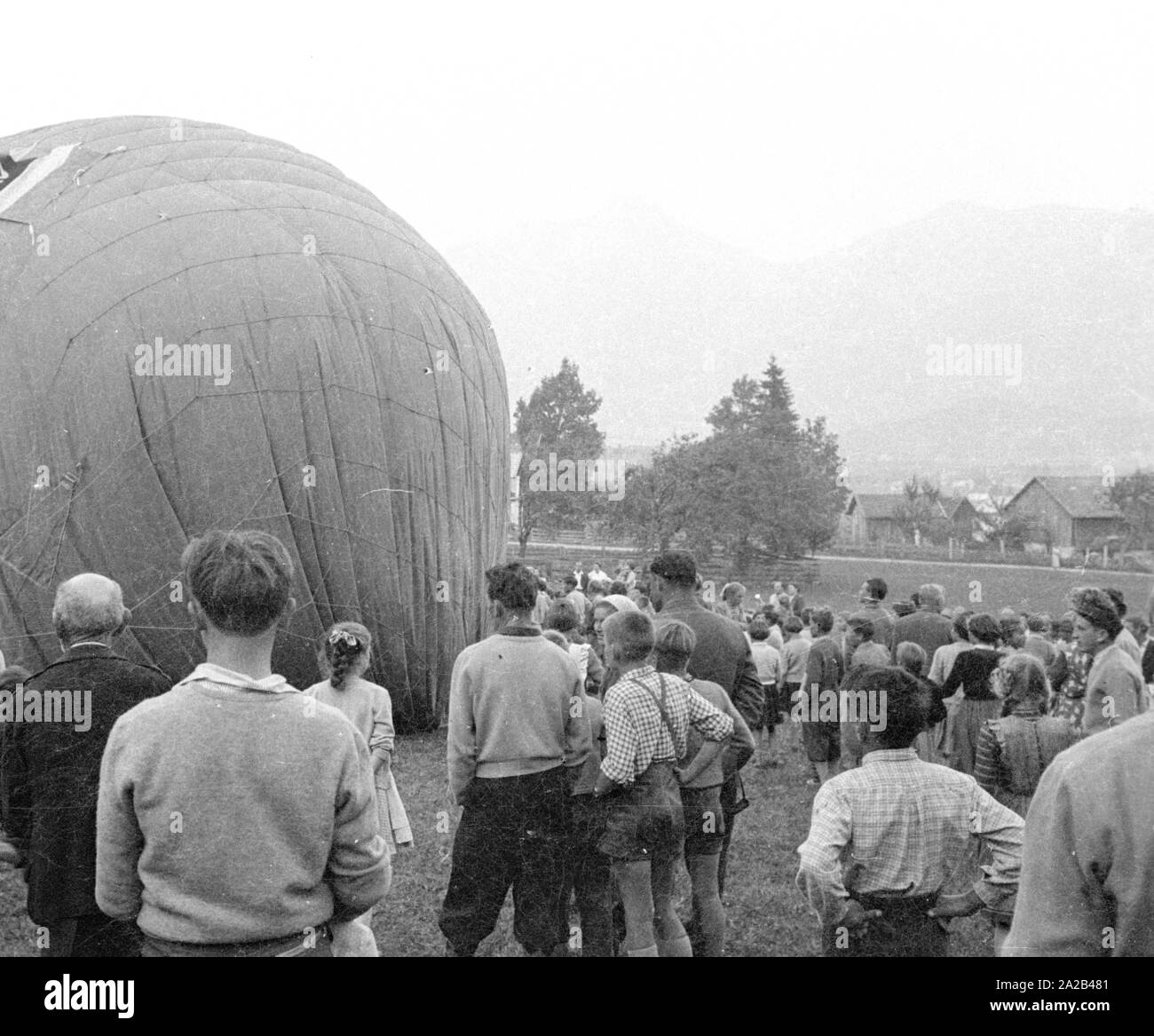 Dopo il suo volo in pallone aerostatico dal Nebelhorn oltre l'Allgaeu Alpi, Alfred Eckert sbarcato presso la città di Reutte in Tirolo. Molti curiosi si sono radunati accanto alla aiutanti. Foto Stock