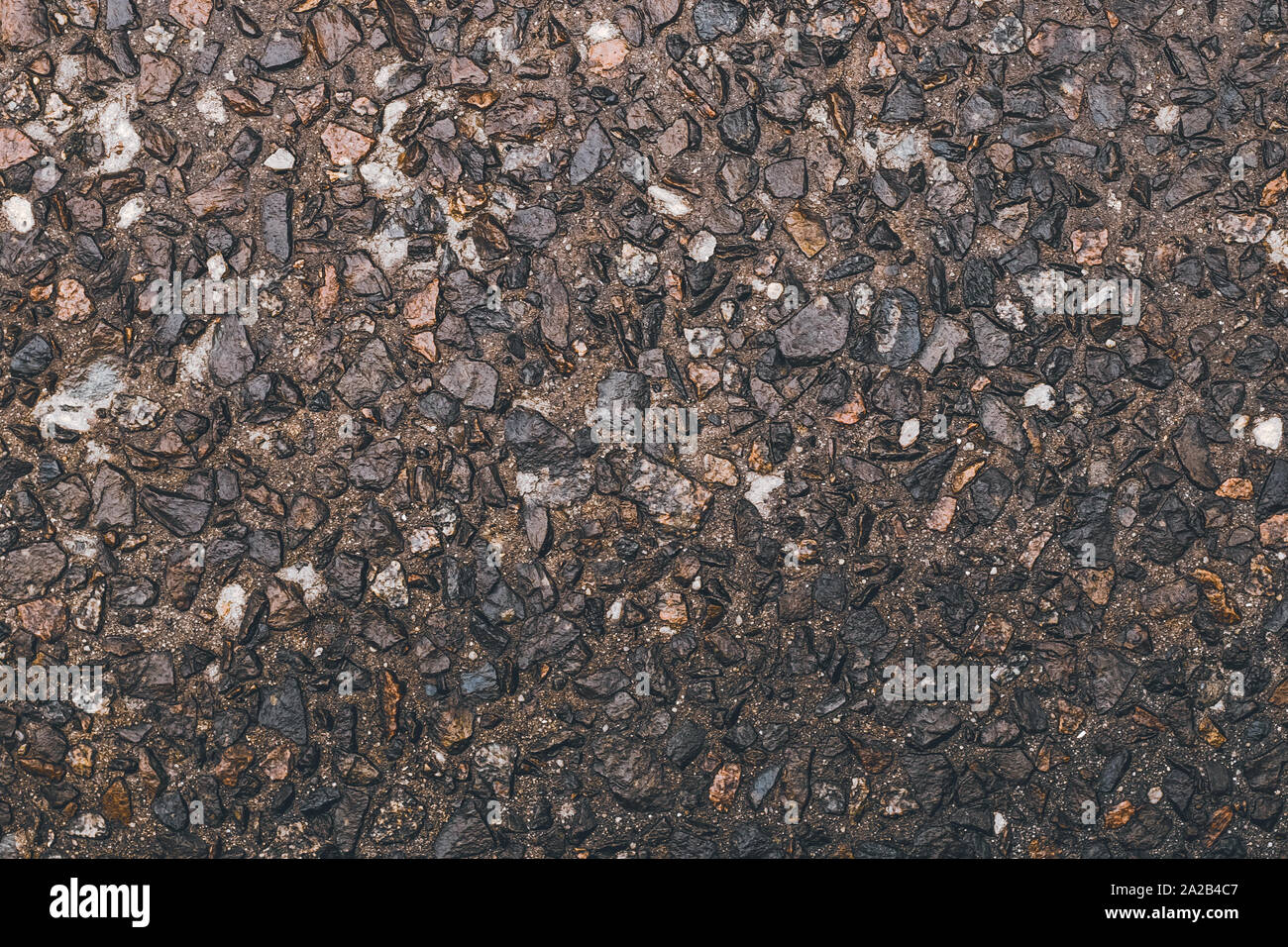 Tessitura grossolana di pietre, ghiaia. Strada superficie grunge. Pietra marrone dello sfondo. Piccoli ciottoli sul pavimento, naturale parete di roccia. Foto Stock