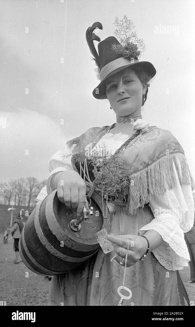 La foto mostra un tradizionalmente vestiti donna con una grappa barile di fronte il palazzo di Nymphenburg. Probabilmente ha effuso schnapps durante i festeggiamenti per il Principe ereditario Rupprecht's ottantacinquesimo compleanno. Foto Stock