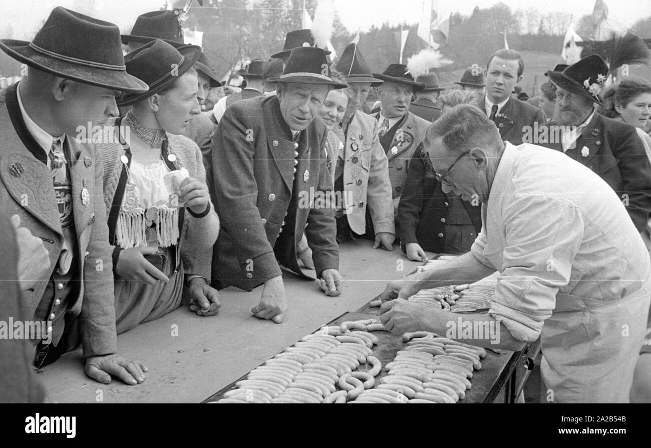 In occasione dell'ottantacinquesimo compleanno del Principe Ereditario Rupprecht, numerose celebrazioni si sono tenute di fronte il palazzo di Nymphenburg. La figura mostra gli ospiti in costume in una salsiccia di stand. Foto Stock