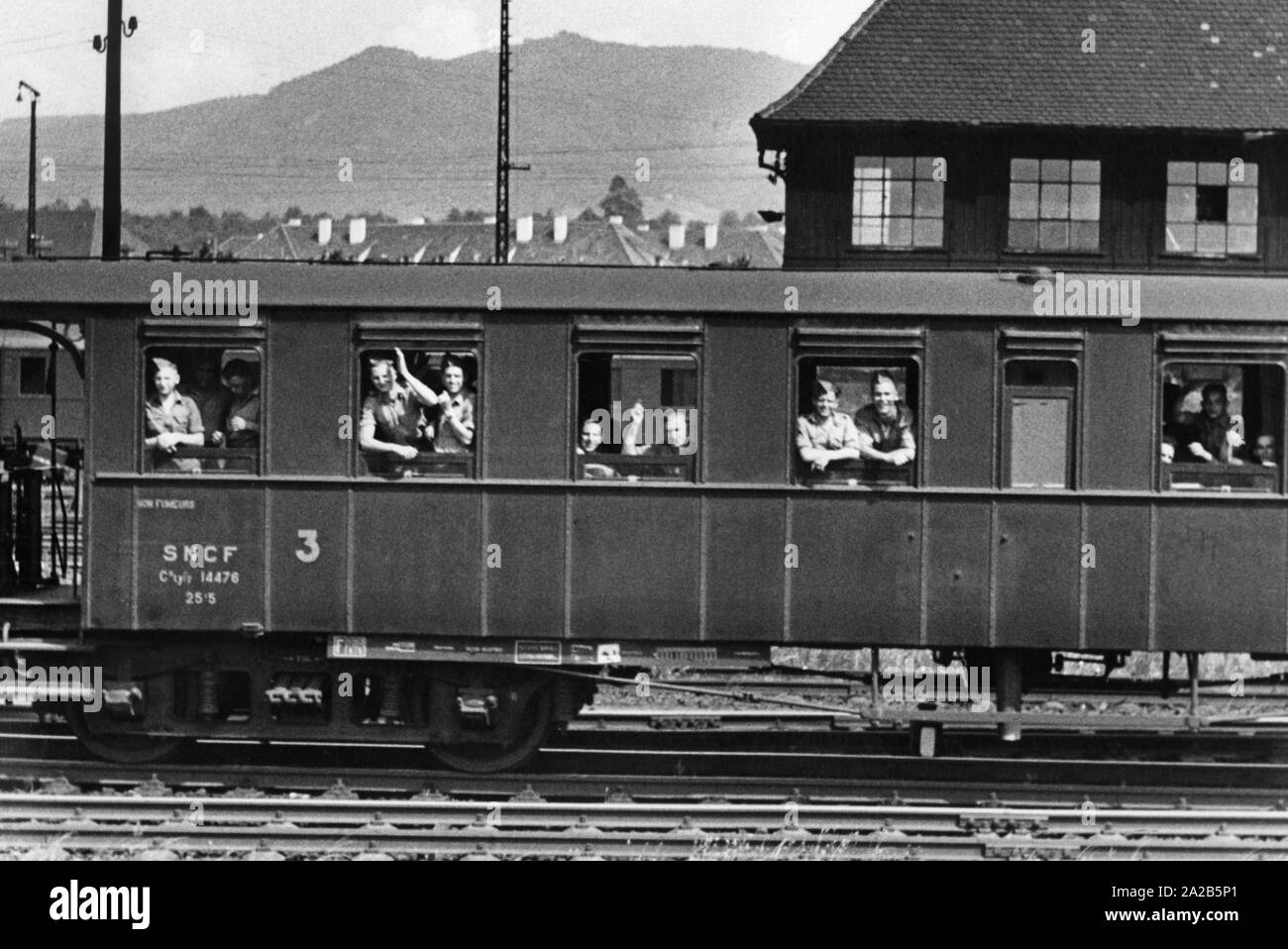 Il treno con la nuova assunzione degli esteri tedesco legionari lascia Offenburg in direzione di Marsiglia. Le reclute in uniforme ridere e wave. Foto Stock