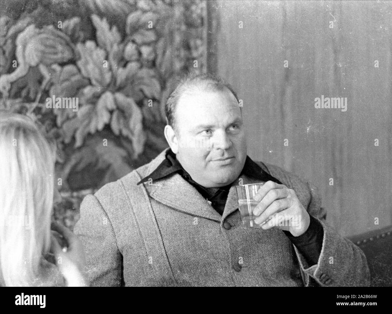Dan Blocker, che svolge il ruolo di Hoss Cartwright nella serie televisiva Bonanza, tenendo in mano un bicchiere d'acqua. Foto Stock