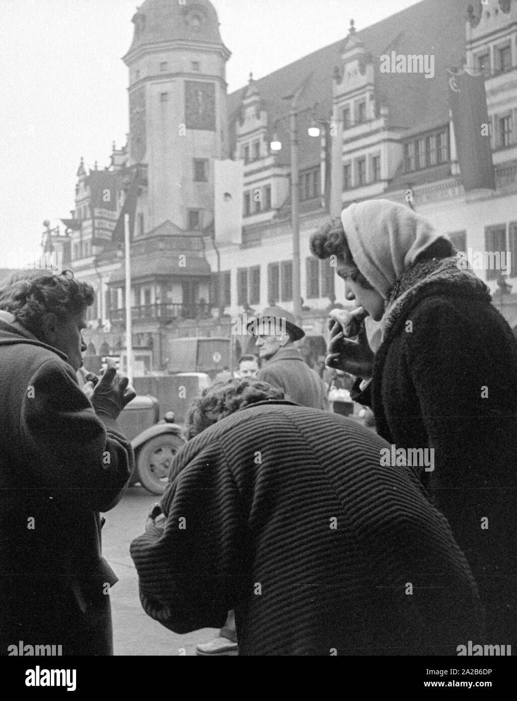 La città durante la Fiera di primavera 1960. Passanti mangiano salsicce fritte. Foto Stock