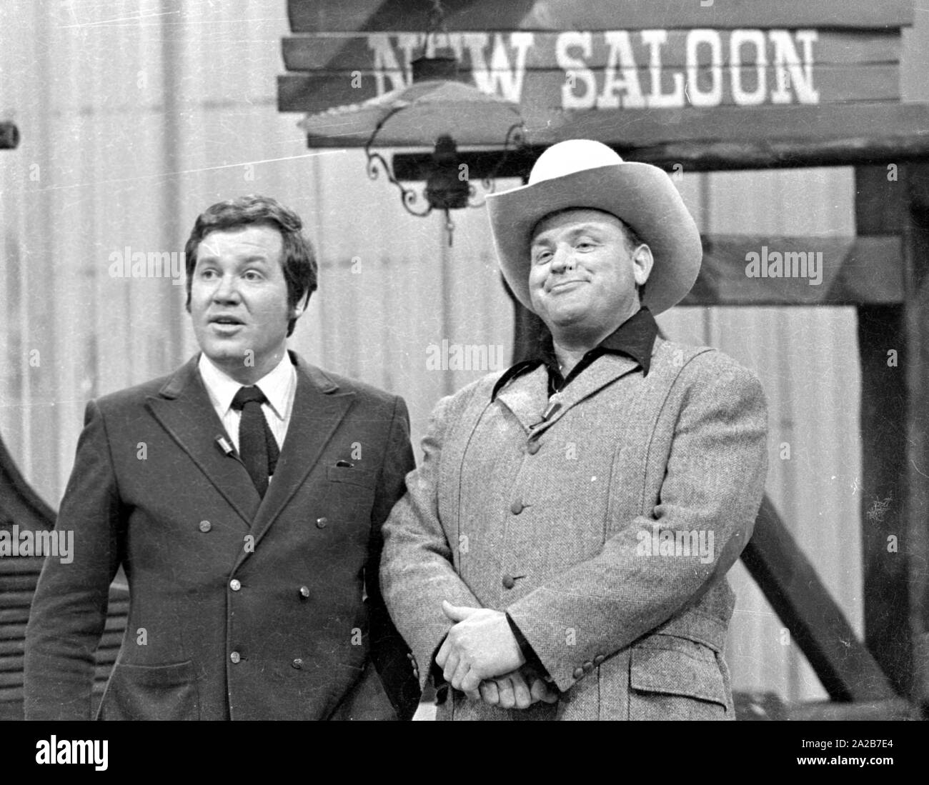 Il impersonator di Hoss da Bonanza, Dan Blocker con Wim Thoelke nella parte anteriore di un 'Saloon' sullo sfondo con la scritta 'nuovo salone' sul 3x9 TV show. Foto Stock