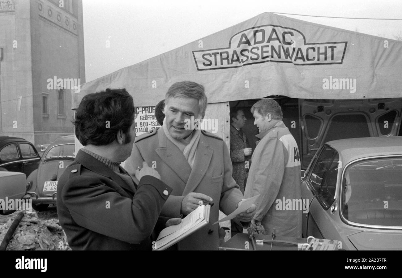 Al Koenigsplatz a Monaco di Baviera, l'ADAC effettua la misura dei gas di scarico. Attualmente una vettura viene testato. L'attore Blacky Fuchsberger (anteriore destro) parla con un tecnico. Foto Stock