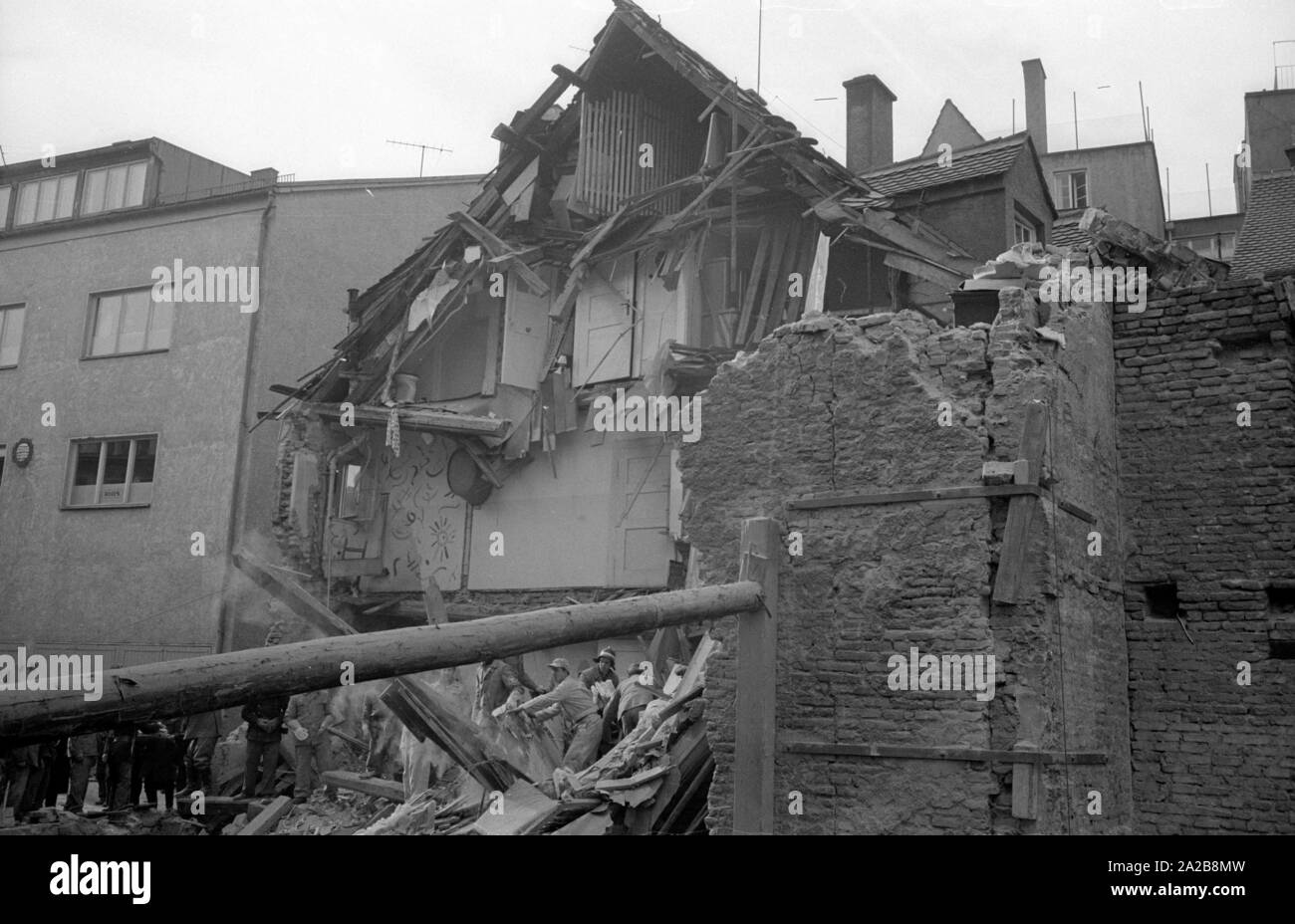 Aiutanti cerca le rovine di una casa crollata a Augsburg. Foto Stock