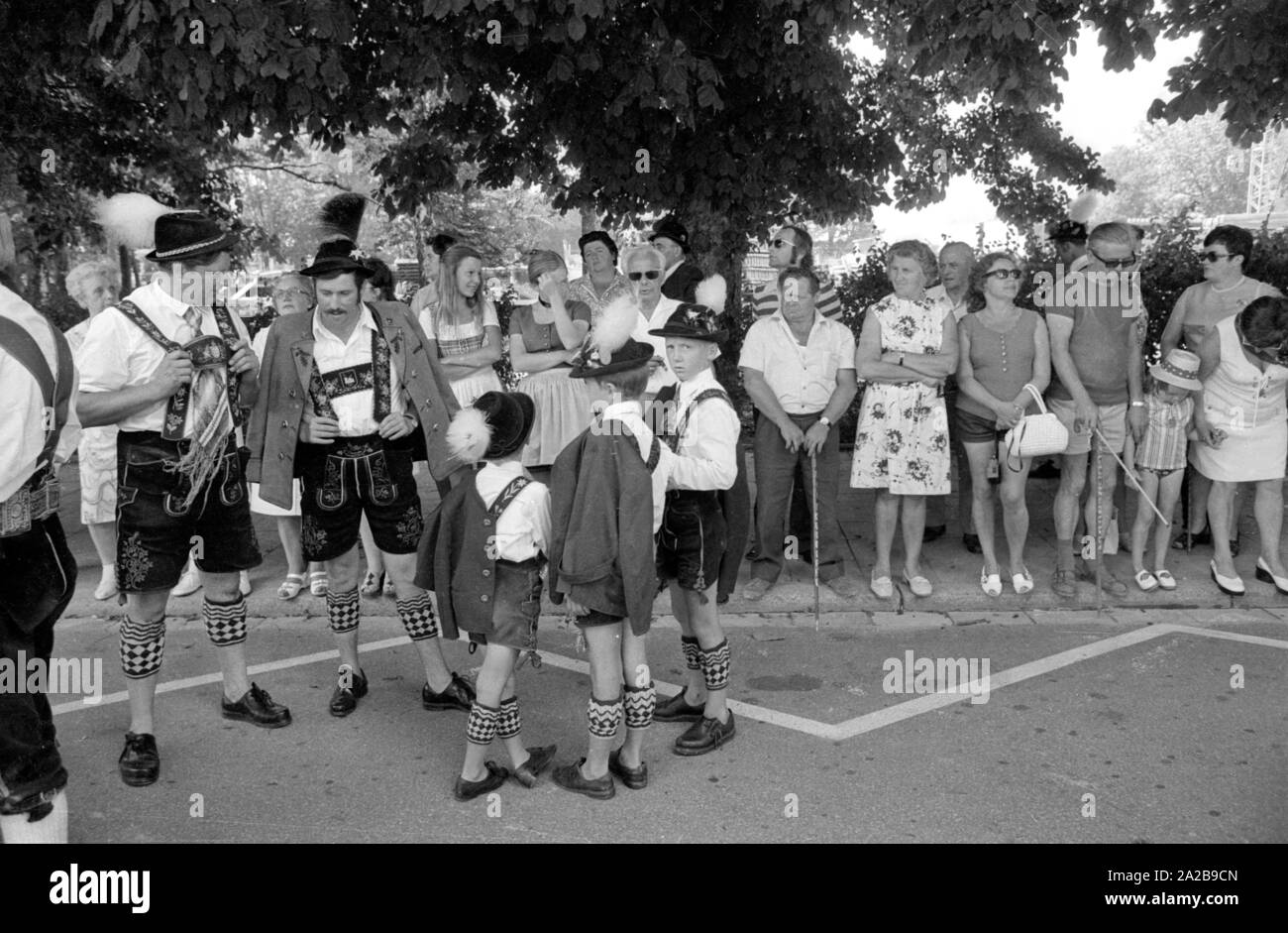 Gli uomini e i ragazzi in costume di un tradizionale sfilata in costume in Alta Baviera. Foto Stock