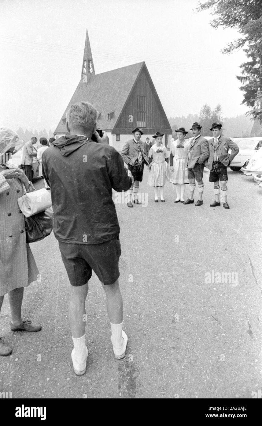 Un uomo prende una foto di persone in abiti tradizionali in un tradizionale sfilata in costume. Foto Stock