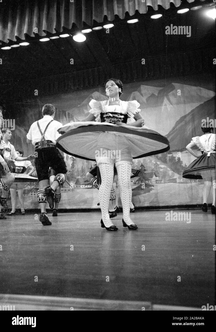 Un ballerino in costume tradizionale con battenti mantello durante una performance dei bavaresi tradizionali danze folk in una città termale in Baviera. Foto Stock