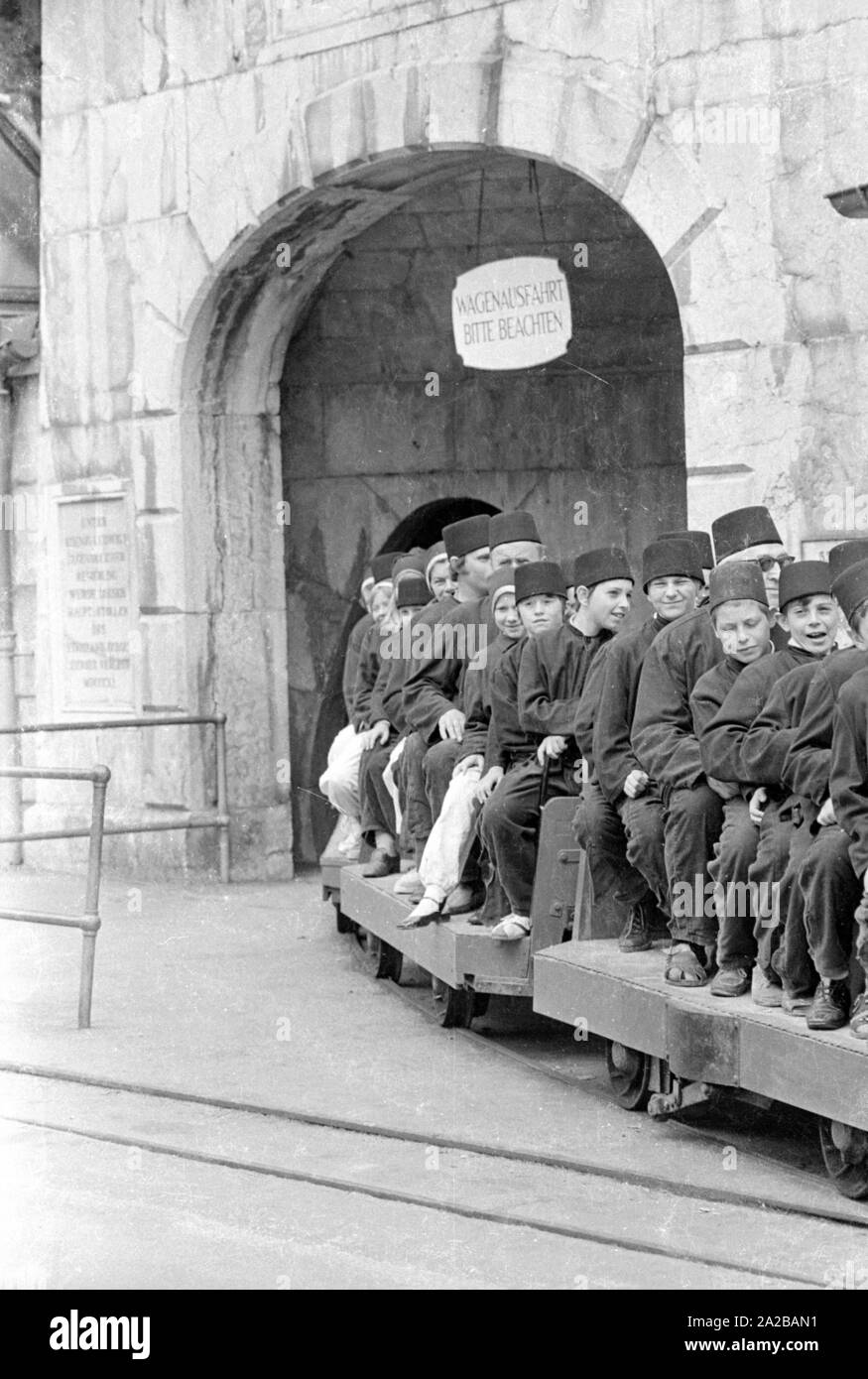 I visitatori della miniera turistica 'Salzbergwerk Berchtesgaden'Start loro gita con un giro sul treno di miniera. Essi sono vestiti in Bergmannskluft (minatore della uniforme). Foto Stock