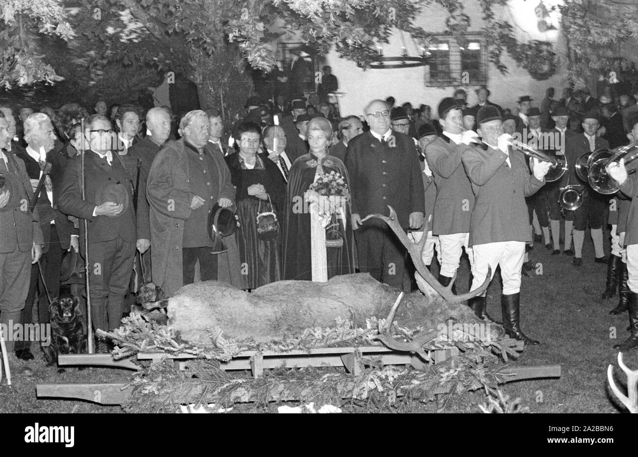 Nel 1971 un festival di caccia ha avuto luogo presso l'Hotel Schloss Fuschl in Hof bei Salzburg. La lussuosa residenza di caccia dal XV secolo è un luogo di incontro per gli ospiti selezionati da tutto il mondo. Nella foto: Il proprietario degli alberghi e master di hunt Carl Adolf Vogel (quarta da sinistra) e sua moglie, l'attrice tedesca Winnie Markus (sesto da sinistra) stand in fila anteriore mentre il sacerdote consacra la cava. Foto Stock