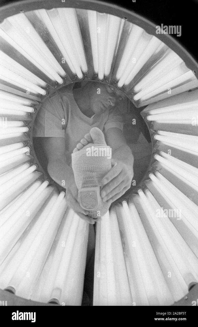 Un piede intonacata in un tubo luminoso. Presumibilmente questo è 'Lightcast 3M', un bendaggio materiale che indurisce sotto luce ultravioletta. Foto Stock