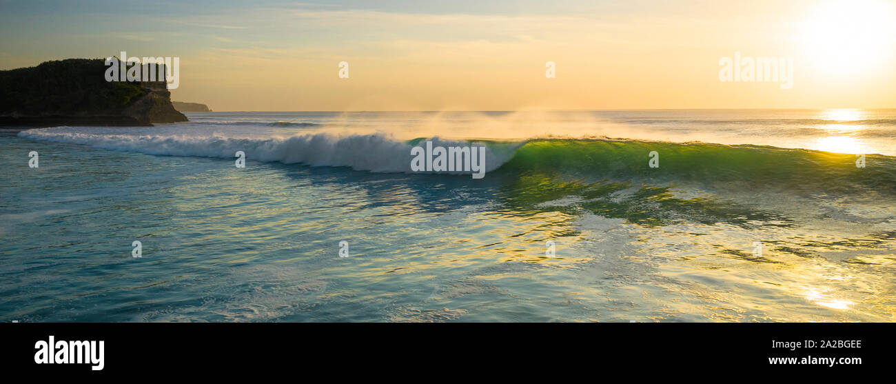 Grandi onde tropicali di schiantarsi al tramonto a Bali Foto Stock