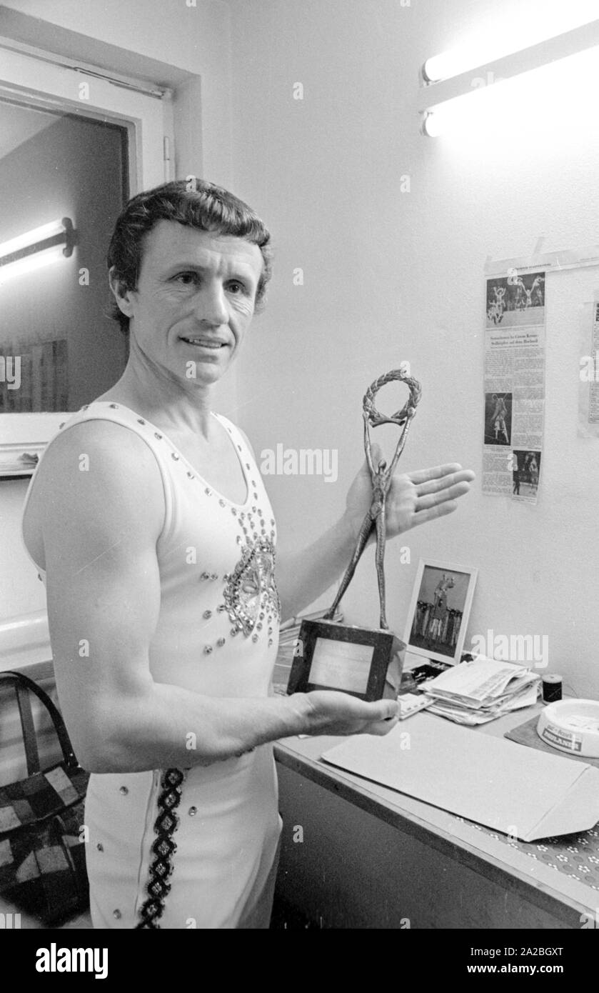 Un funambolico artista - probabilmente dal Circus Krone - presenta un trofeo. Foto Stock