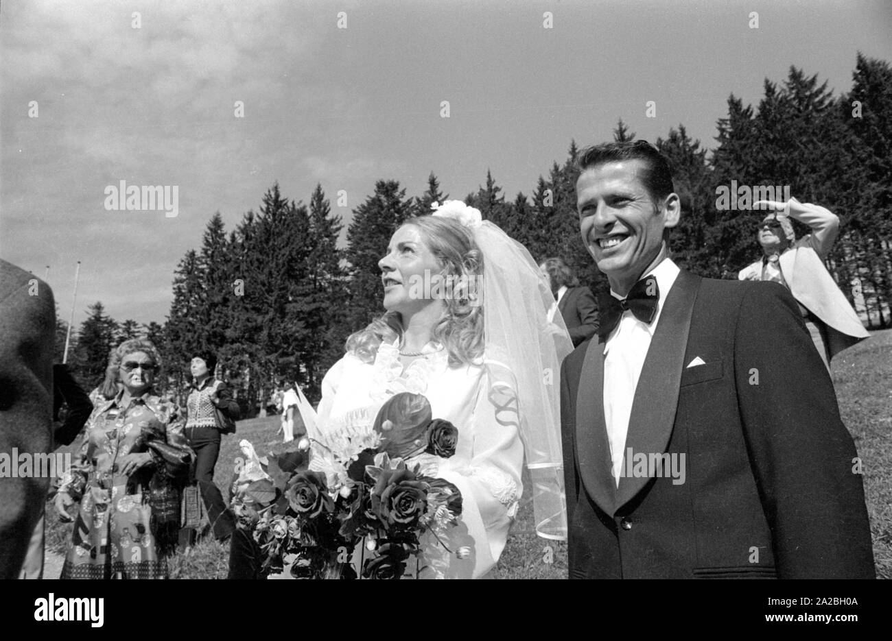 Per il matrimonio di questa coppia di sposi sul Schliersbergalm Schliersee ad alcuni ospiti volare con il paracadute. Foto Stock Per il matrimonio di questa coppia di sposi sul Schliersbergalm Schliersee ad alcuni ospiti volare con il paracadute. Foto Stock