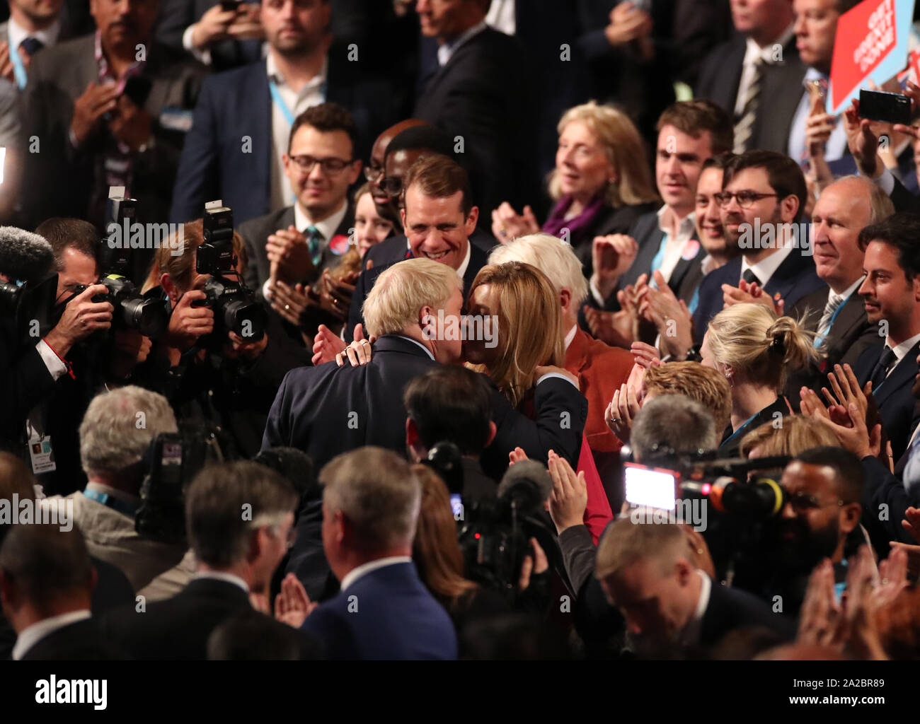 Il primo ministro Boris Johnson e Carrie Symonds abbracciare presso il congresso del partito conservatore al Manchester Convention Center. Il primo ministro riceve applausi per il suo intervento da parte del pubblico. Foto Stock