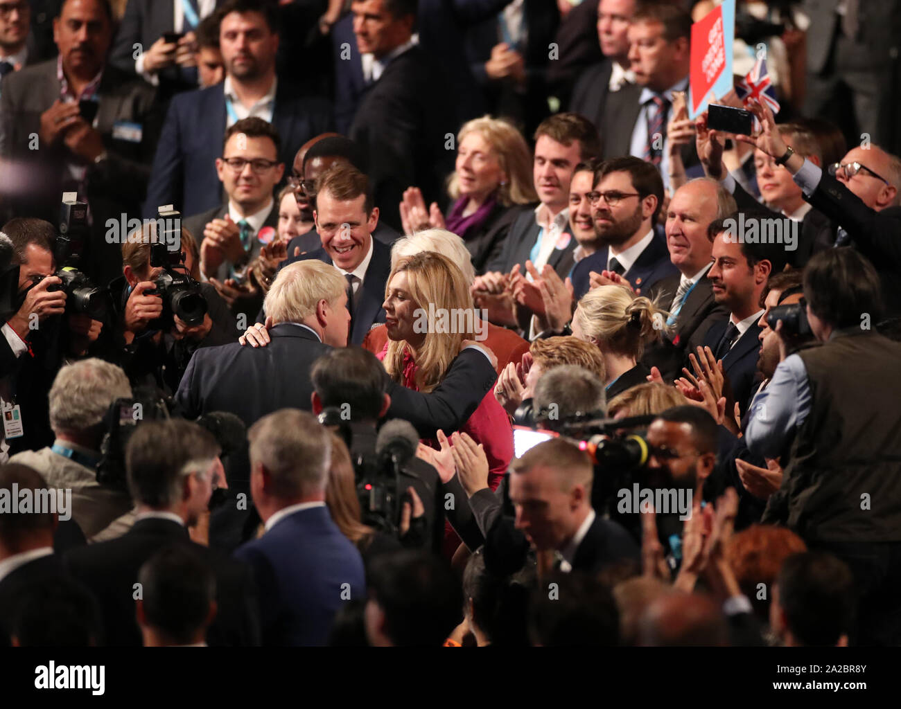 Il primo ministro Boris Johnson e Carrie Symonds abbracciare presso il congresso del partito conservatore al Manchester Convention Center. Il primo ministro riceve applausi per il suo intervento da parte del pubblico. Foto Stock