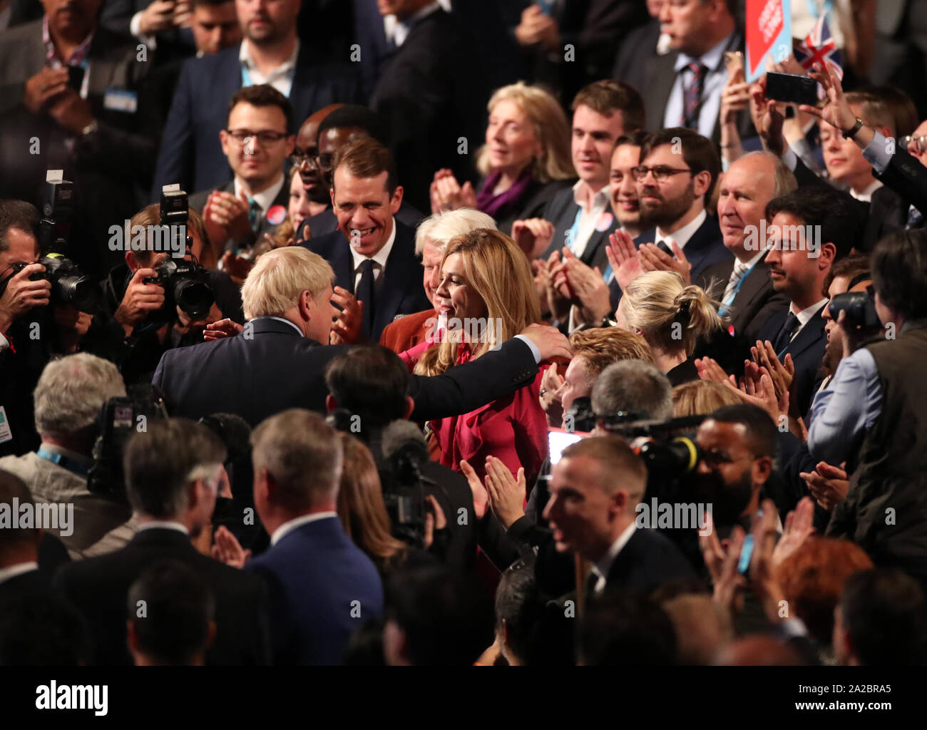 Il primo ministro Boris Johnson e Carrie Symonds abbracciare presso il congresso del partito conservatore al Manchester Convention Center. Il primo ministro riceve applausi per il suo intervento da parte del pubblico. Foto Stock