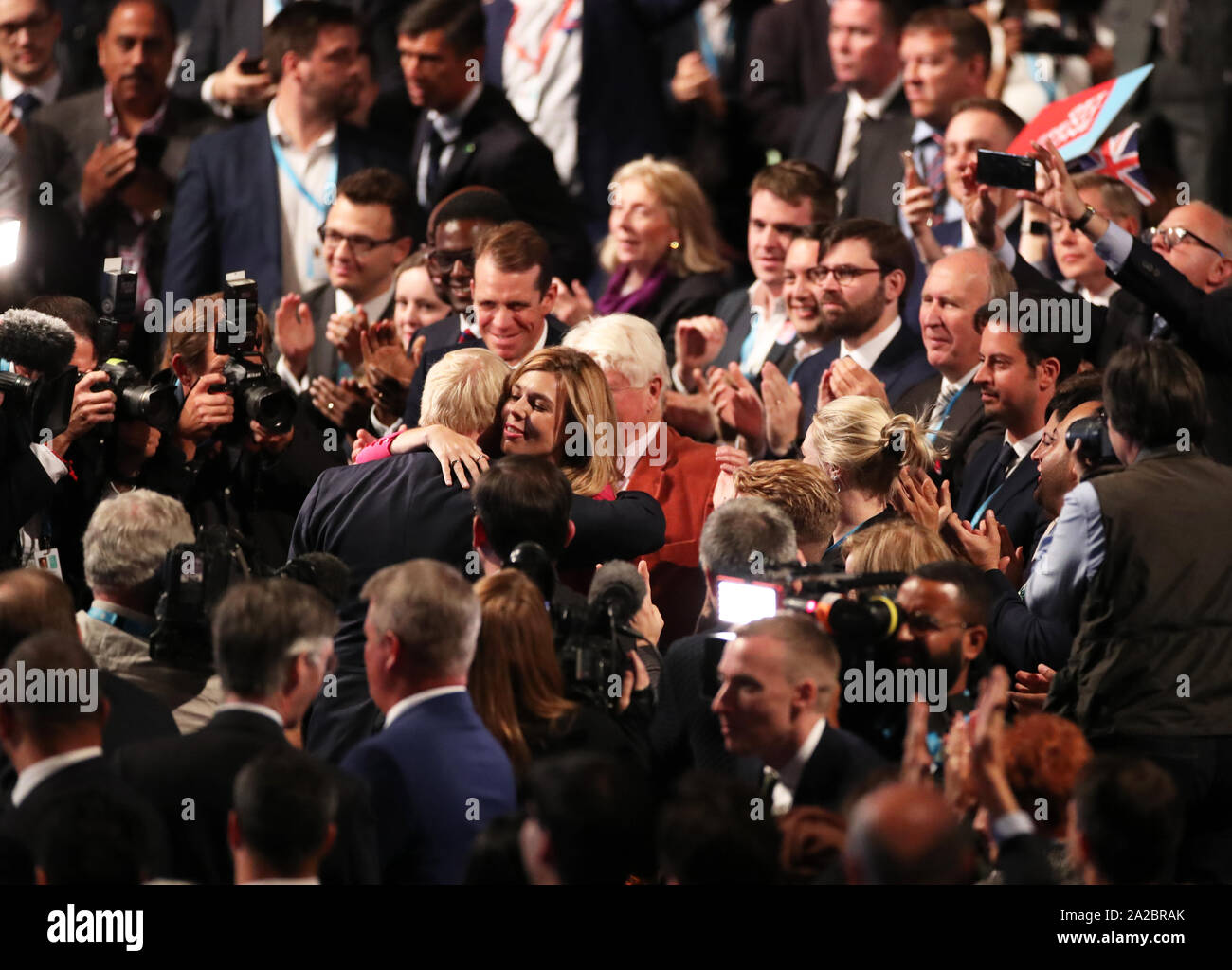 Il primo ministro Boris Johnson e Carrie Symonds abbracciare presso il congresso del partito conservatore al Manchester Convention Center. Il primo ministro riceve applausi per il suo intervento da parte del pubblico. Foto Stock