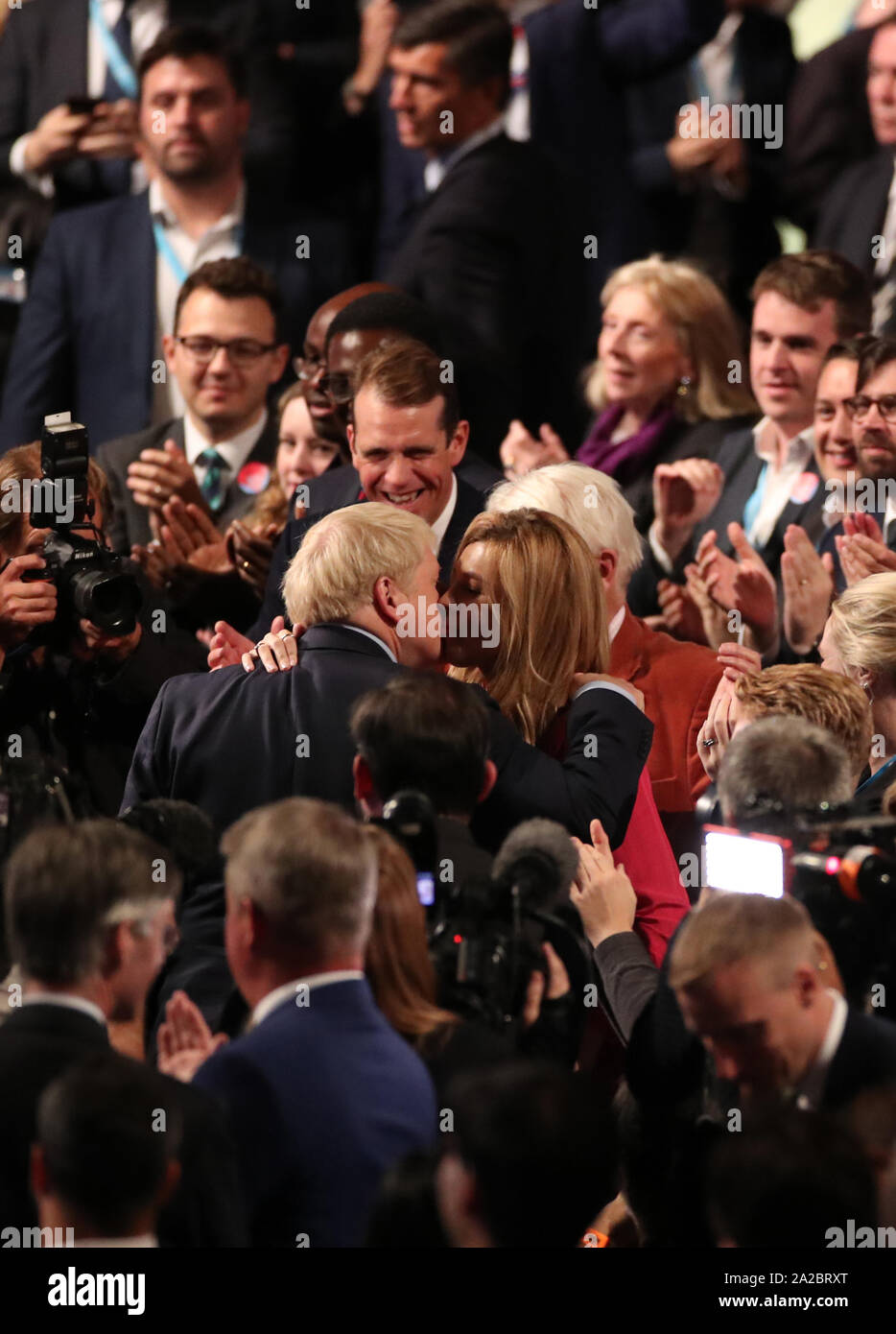 Il primo ministro Boris Johnson e Carrie Symonds abbracciare presso il congresso del partito conservatore al Manchester Convention Center. Il primo ministro riceve applausi per il suo intervento da parte del pubblico. Foto Stock