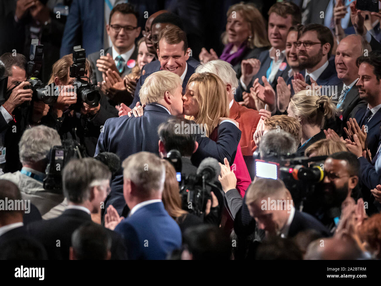 Il primo ministro Boris Johnson e Carrie Symonds abbracciare presso il congresso del partito conservatore al Manchester Convention Center. Il primo ministro riceve applausi per il suo intervento da parte del pubblico. Foto Stock