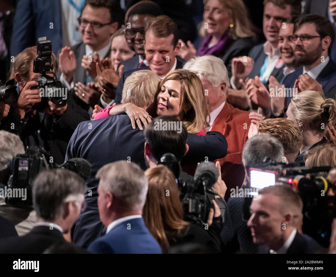 Il primo ministro Boris Johnson e Carrie Symonds abbracciare presso il congresso del partito conservatore al Manchester Convention Center. Il primo ministro riceve applausi per il suo intervento da parte del pubblico. Foto Stock
