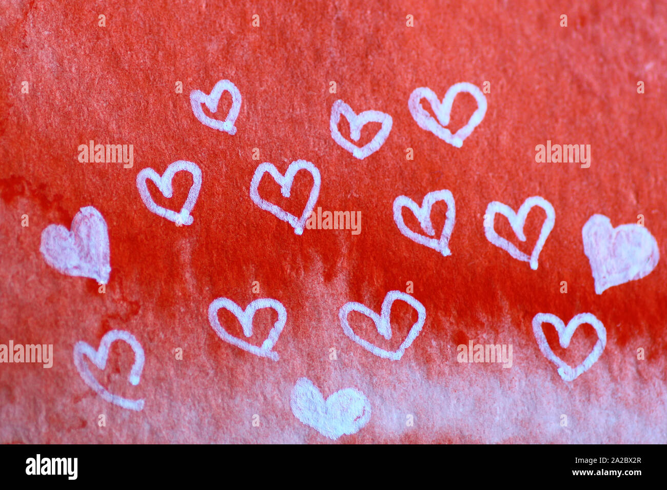 Poco bianco cuori manoscritta su un rosso sfondo ad acquerello Foto Stock