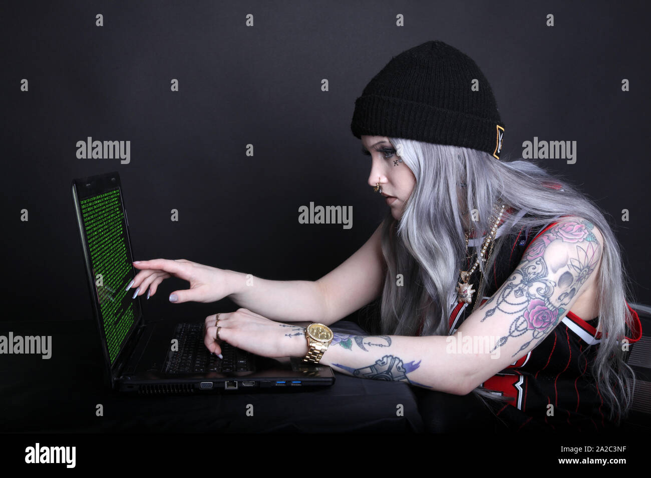 Vista laterale della donna millenario su laptop guardando l'hacking computer codice sullo schermo la chiave di basso 2019 Foto Stock