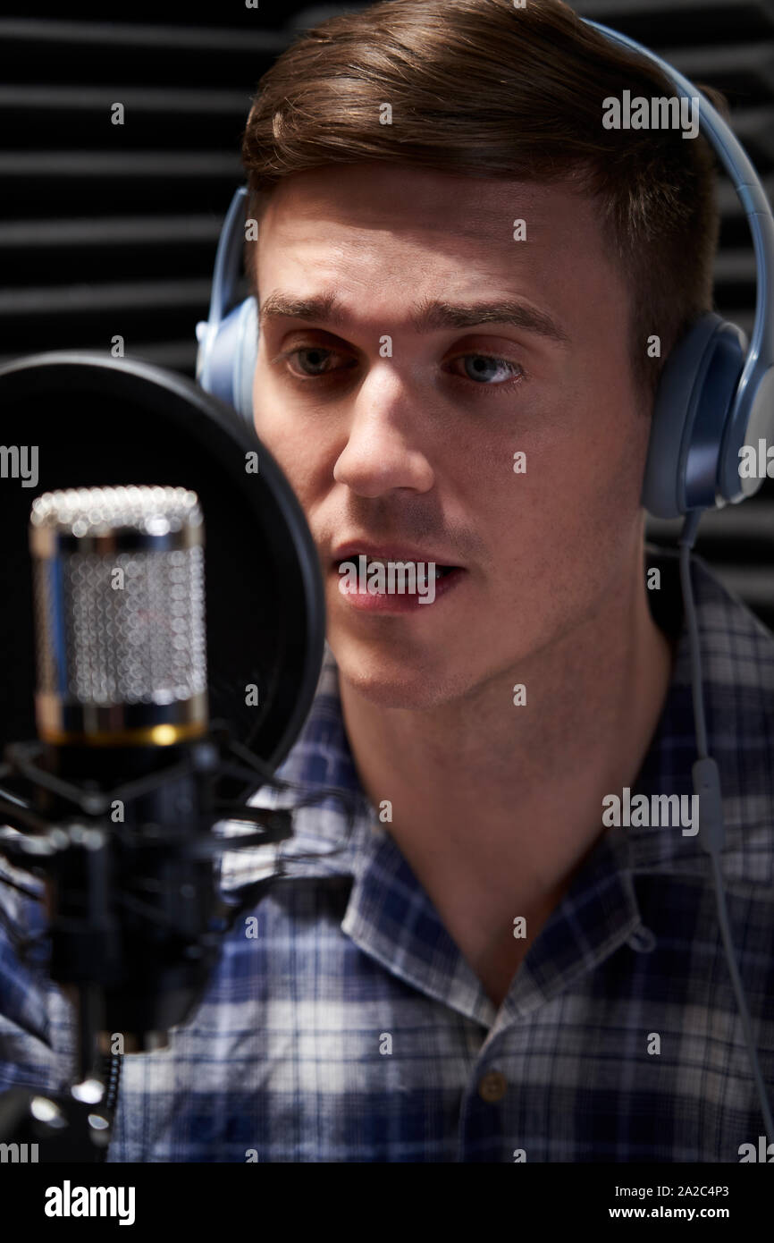 Voce maschile su artista in studio di registrazione parlando nel microfono Foto Stock