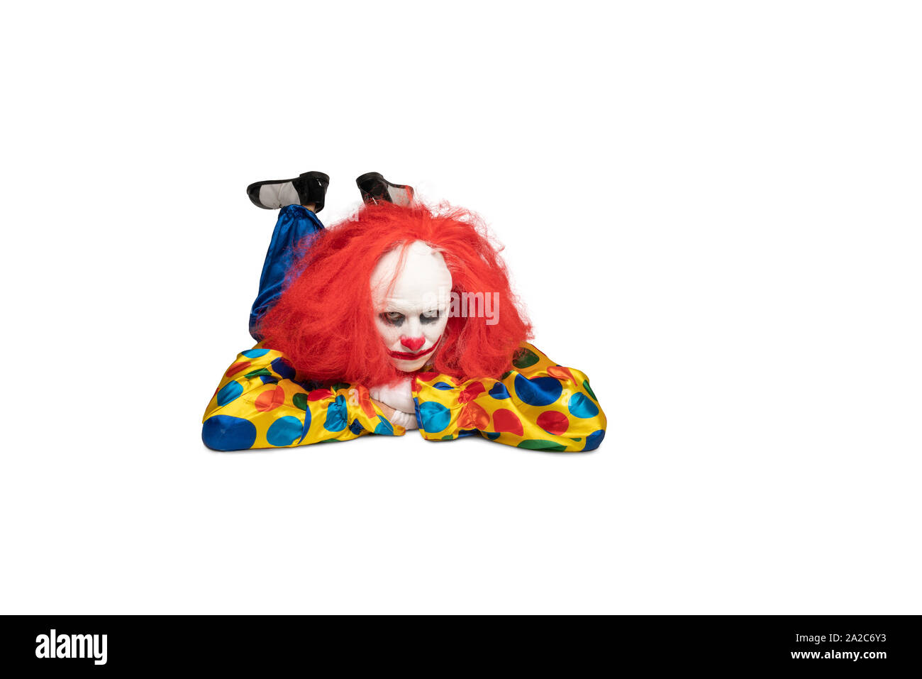 Annoiato clown giace sul piano e guarda la telecamera Foto Stock