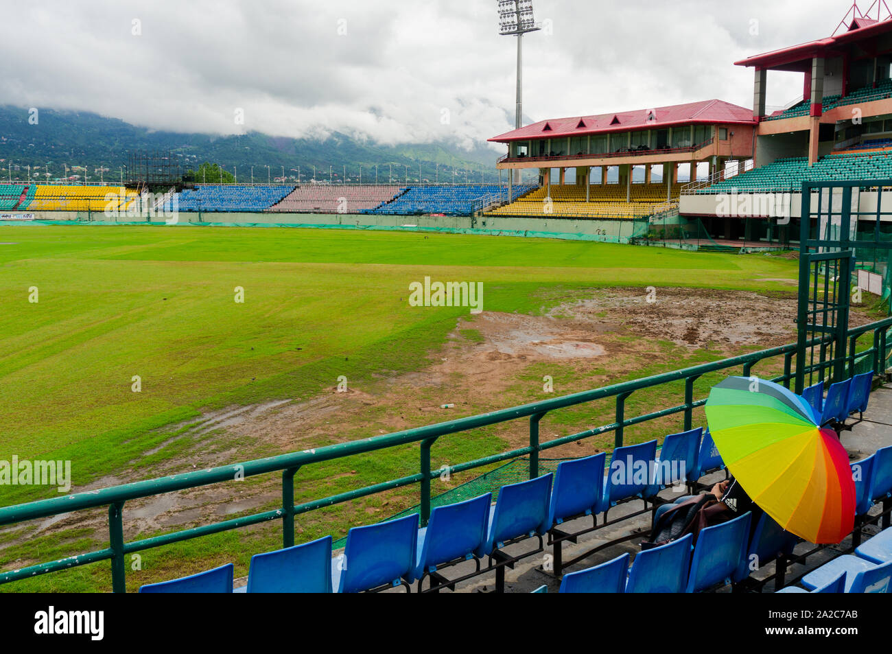 Ombrello coloratissimo sulle sedi di Dharamshala himachal Cricket Stadium Foto Stock