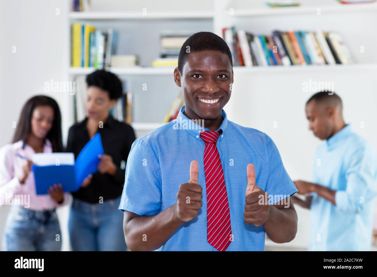 Il successo americano africano imprenditore con cravatta e colleghi in ufficio Foto Stock