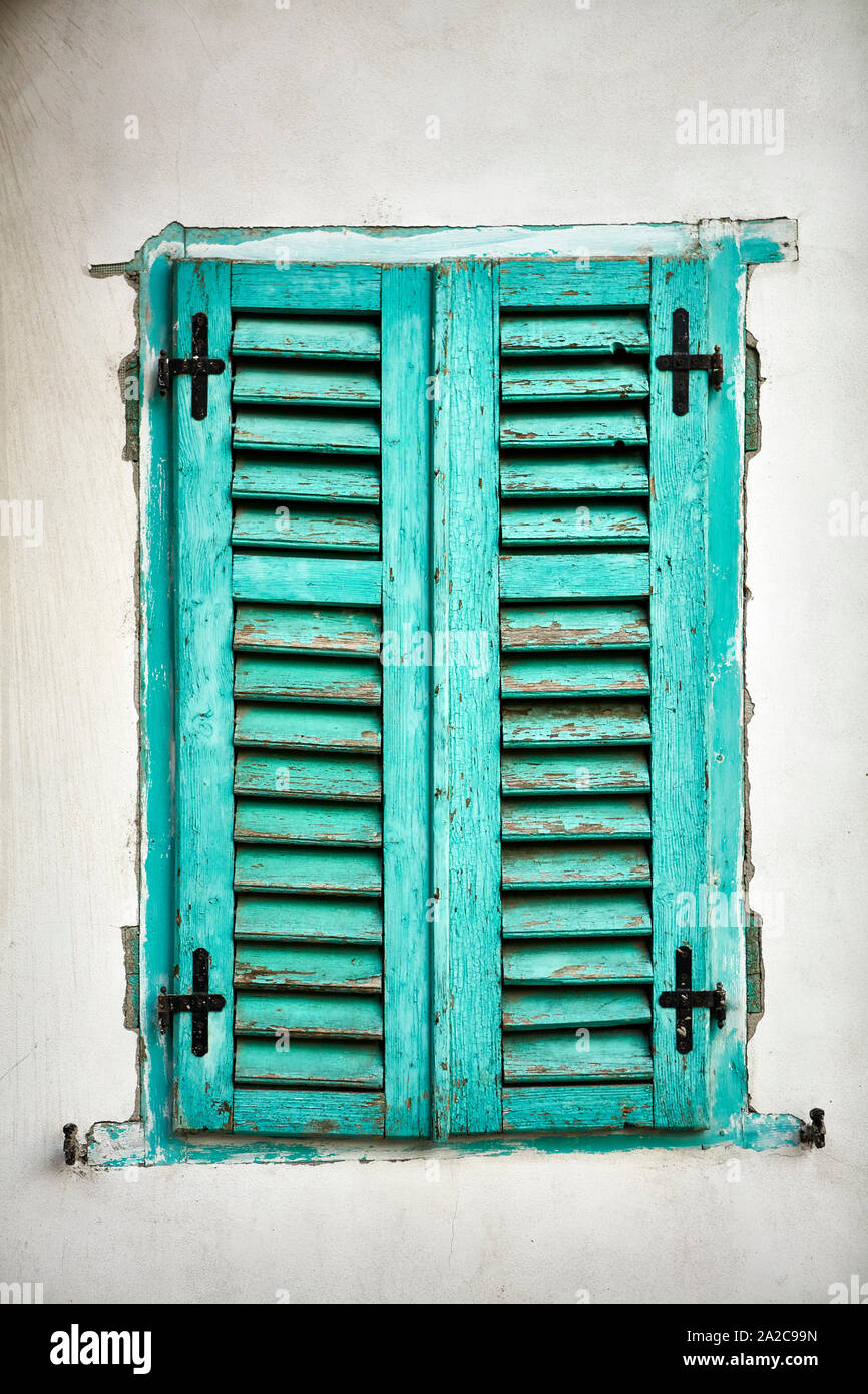 Rustico finestra esterna chiusa con tavola di legno persiane in turchese colore verde Foto Stock