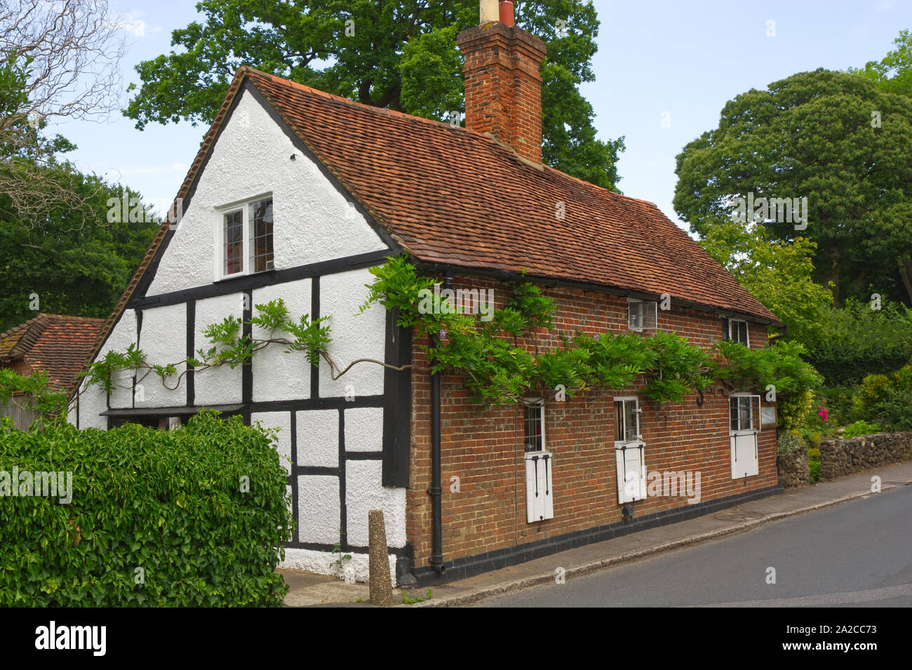 Guildford, Inghilterra - Agosto 2, 2019: imbiancate a calce e mattoni e piastrelle Cottage a Shere nel Surrey. Foto Stock