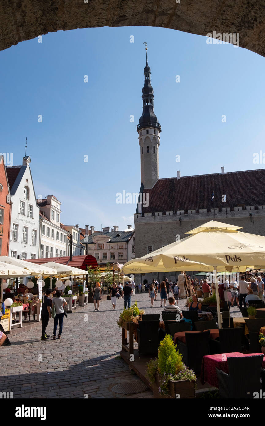 Guardando attraverso arco verso il mercato dell'artigianato sulla piazza del Municipio nella città vecchia di Tallinn, Estonia Foto Stock