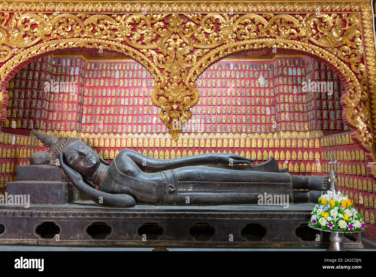 Buddha reclinato all'interno del Hor Pha Daj Sai nyaat (Cappella rossa) al Wat Xieng Thong tempio buddista, Luang Prabang, Luang Prabang provincia, settentrionale Foto Stock