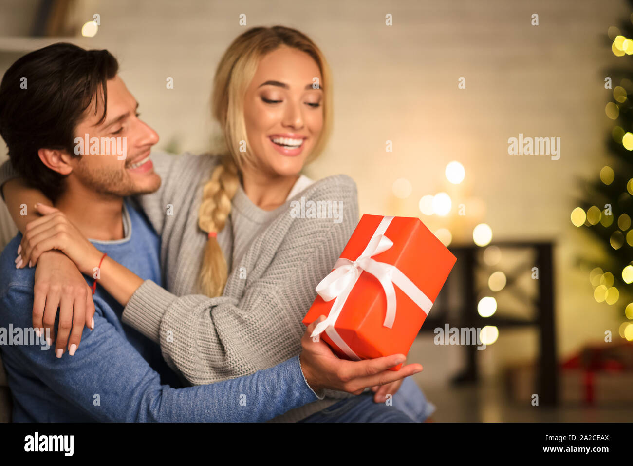 Matura per celebrare il Nuovo Anno, uomo dando presente alla moglie Foto Stock