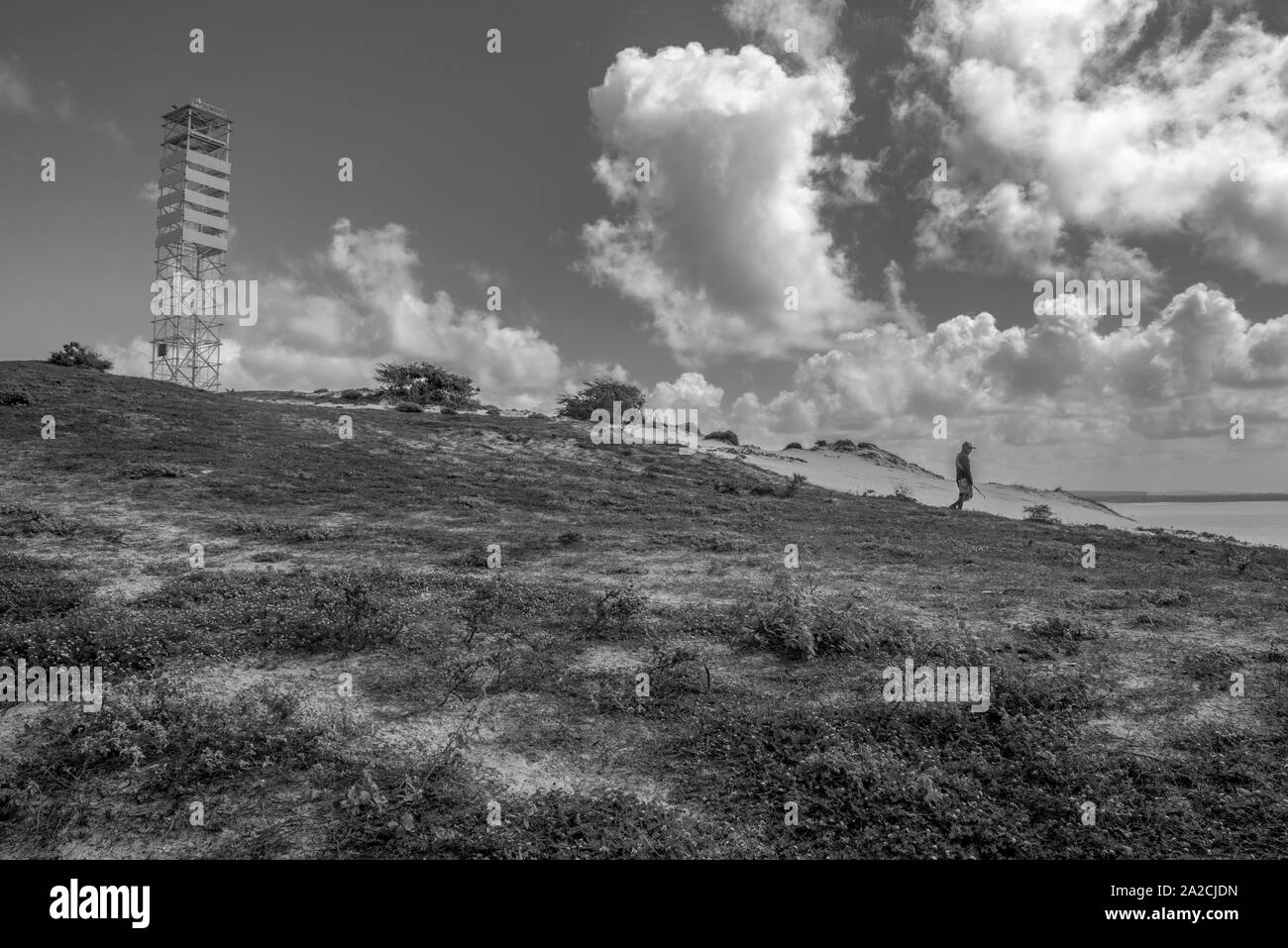 Fisherman andando giù per la collina di sabbia nelle vicinanze torre di osservazione Foto Stock