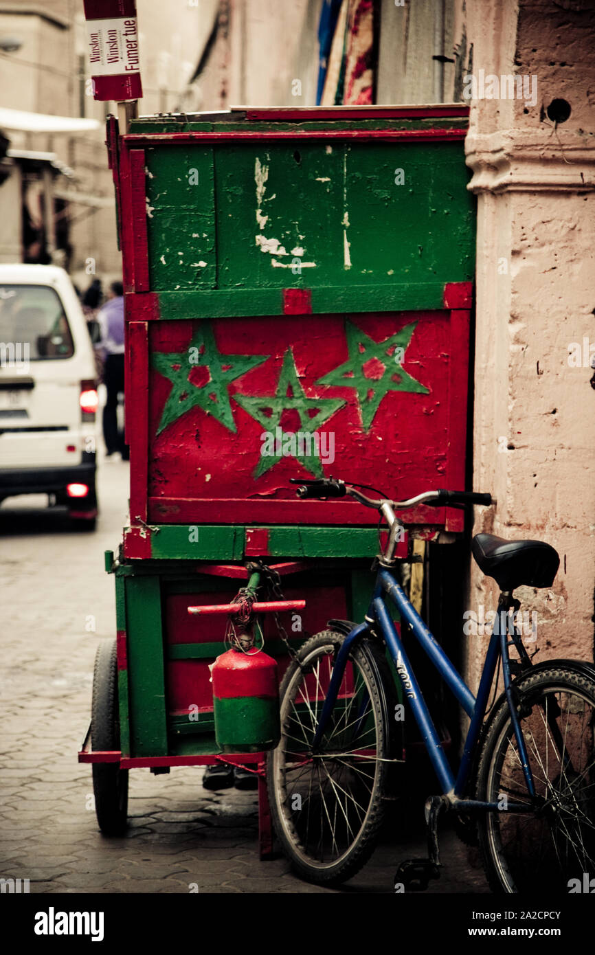 Carrello per la vendita quadrata di prodotti agricoli con i colori sociali e i simboli della bandiera nazionale marocchina a Marrakech, Marocco Foto Stock