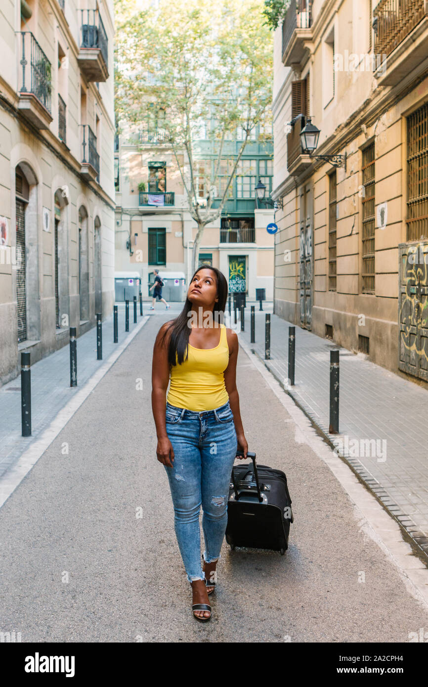 Giovane ragazza turistico è di camminare sulla strada in una città europea alla ricerca di alloggio Foto Stock