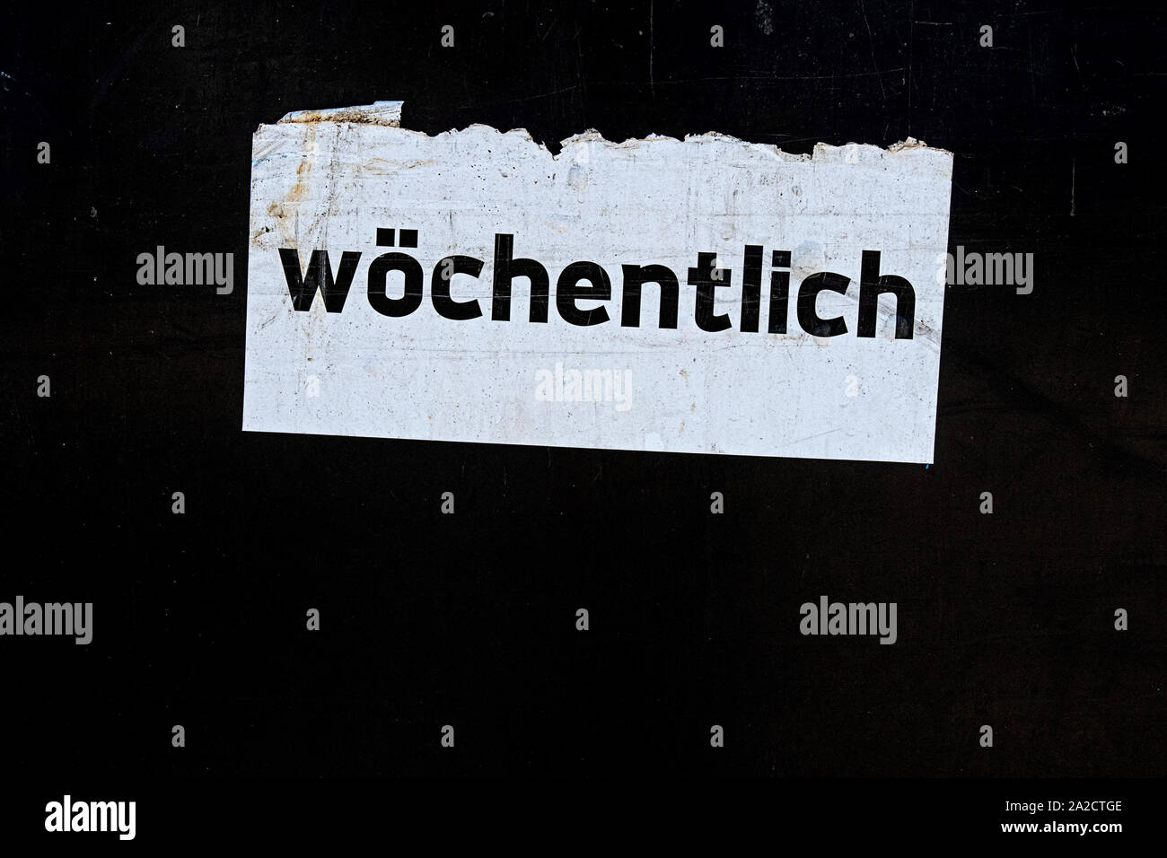 La parola scritta settimanale in lingua tedesca su un foglio di carta bianca segno, tradotto settimanalmente Foto Stock