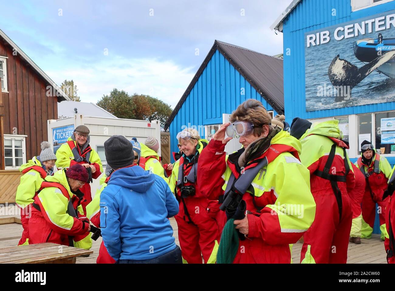 Husavik, Islanda - 25 Settembre 2019: turisti sempre rifornita in secco tute e giubbotti di salvataggio e gli occhiali di protezione pronto per andare a guardare le balene su una nervatura. Foto Stock