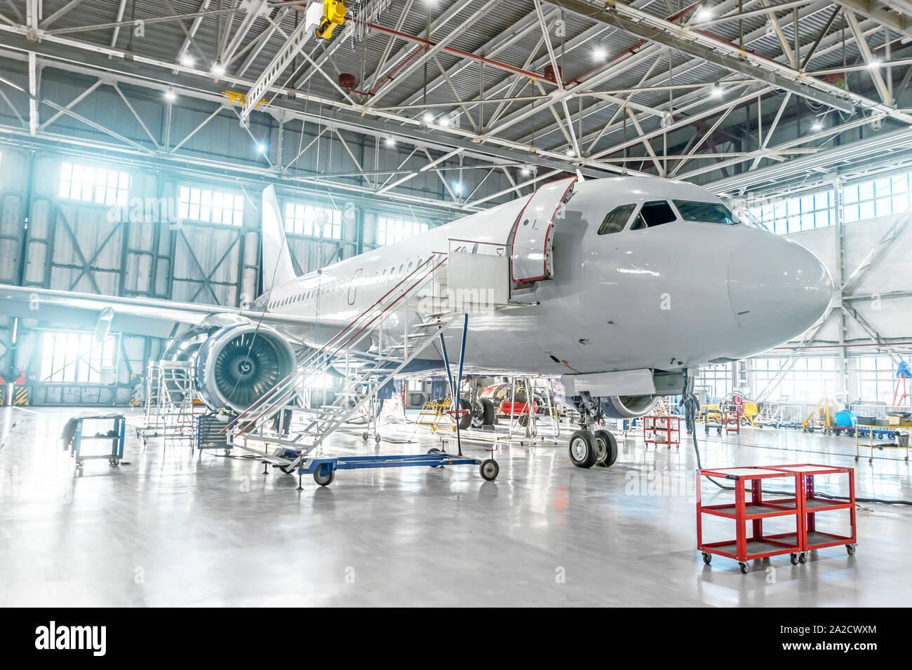 Aeromobili sotto manutenzione, controllare i sistemi meccanici per operazioni di volo. Piano nell'hangar. Foto Stock